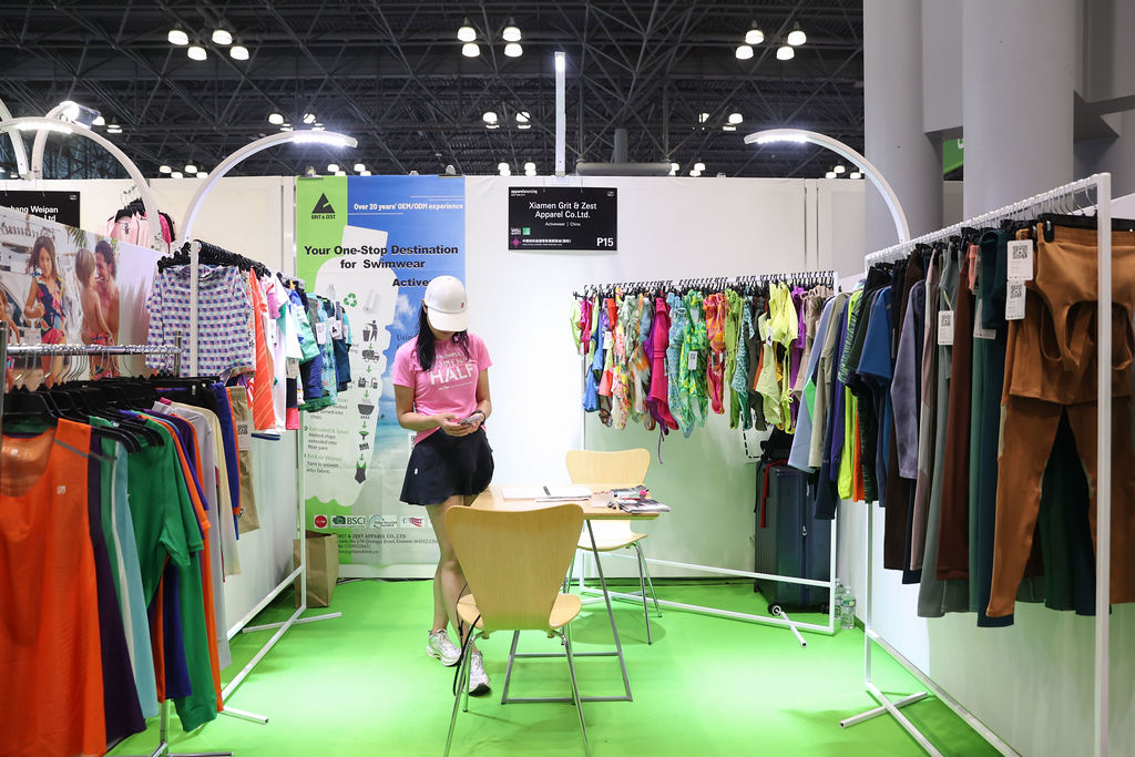 Exhibitor booth displaying colorful swimwear and activewear at Texworld New York trade show.