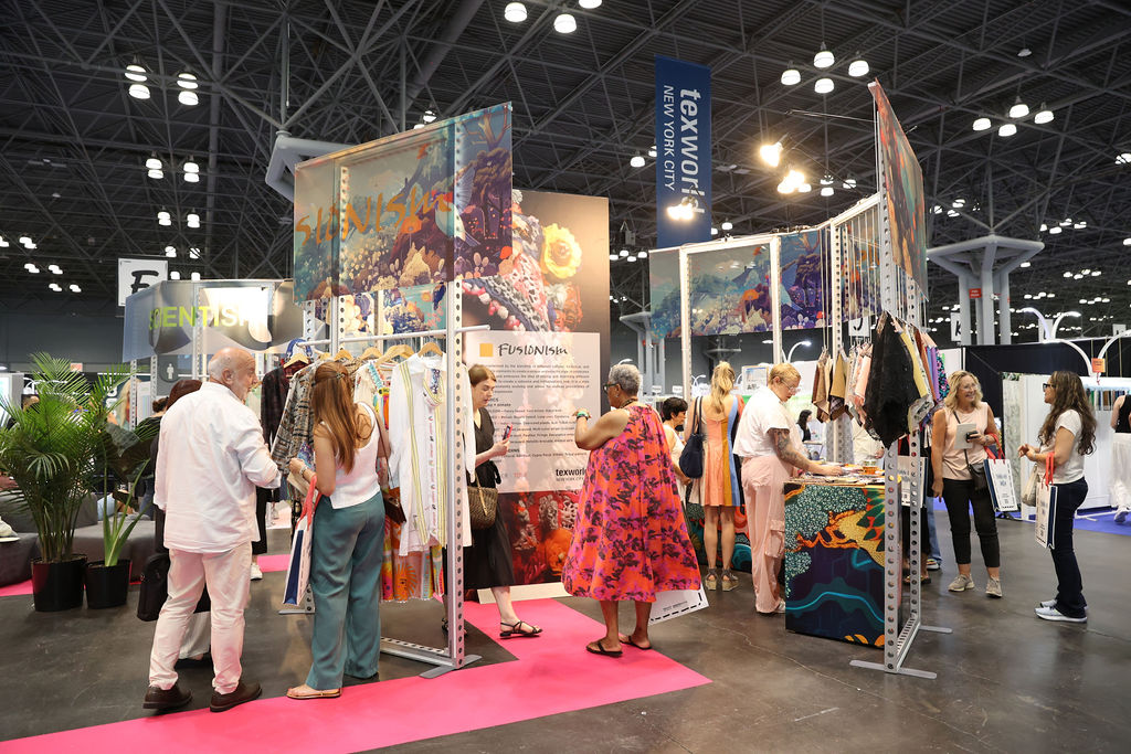 Attendees exploring diverse textile designs at a booth during Texworld New York.